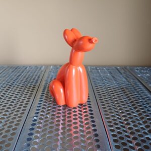 Zittend oranje ballonhondje