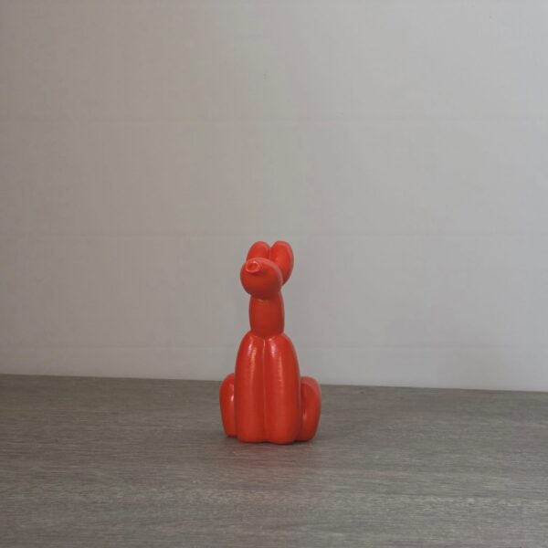 Zittend oranje ballon hondje